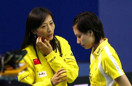 Newly-retired Olympic badminton champion Zhang Ning (L) instructs former teammate Xie Xingfang at the ongoing China Open Badminton event in Shanghai November 19, 2008. Zhang retained her singles title in the Beijing Olympics in August and now coaches the women's team. 