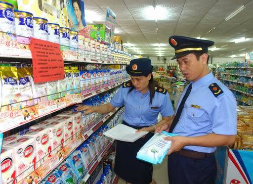 Workers from the law enforcement agency of Pingnan County in Guangxi Zhuang Autonomous Region examine dairy products in a supermarket of the county. Chinese central government launched a major campaign to reform its dairy industry in an attempt to restore consumer confidence on November 20, 2008. [Xinhua photo]