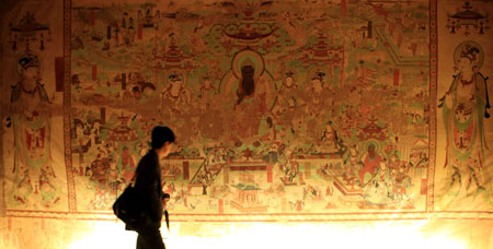 Visitors watch the ectype of No. 25 cave of the Mogao Cave in the Chinese Culture Center of Paris, France, Nov. 18, 2008.