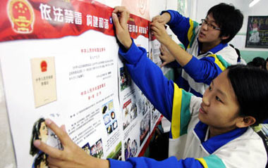 Students stick on the placard on National Narcotics Ban Awareness for All the Public, in the classroom of Yuhong Middle School, in north China's Tianjin Municipality, Nov. 19, 2008. Policemen on duty get on the campus to promote the knowledges and discretion of students on their understanding of the drugs ban, discerning the narcotics ban, and self-protection from drugs as well.