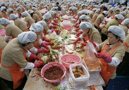 Employees of Korea Yakult make the traditional side dish 'kimchi', or fermented cabbage, during a donation drive in front of Seoul city hall November 20, 2008. About 5,000 of the company's employees participated in the event on Thursday, held in six cities including Seoul, Busan and Incheon, to make kimchi from 120,000 cabbages to donate to the needy during the winter season. 