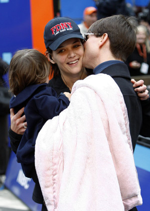 Actress Katie Holmes (C) is greeted by her husband Tom Cruise holding their daughter Suri after Holmes finished the 2007 New York City Marathon in New York November 4, 2007.