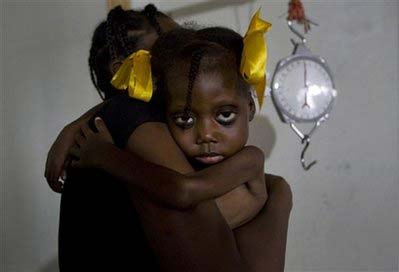 Venecia Lonis, 4, who suffers from malnutrition, is held before being weighed at the Doctors Without Borders hospital in Port-au-Prince, Wednesday, November 19, 2008. 