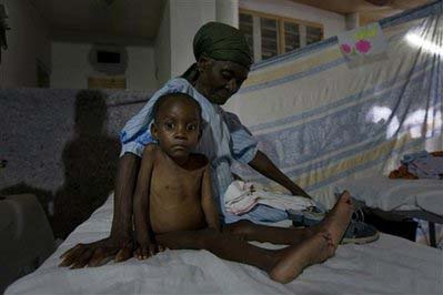 Duclair Mackenson, 5, who suffers from malnutrition, sits in a bed with an unidentified woman at the Doctors Without Borders hospital in Port-au-Prince, Wednesday, November 19, 2008. 