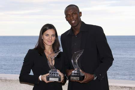 Russia's Yelena Isinbayeva (L) and Jamaica's Usain Bolt display their IAAF World Athlete of the Year trophies ahead of the annual global awards ceremony in Monaco November 23, 2008. [Xinhua/Reuters]