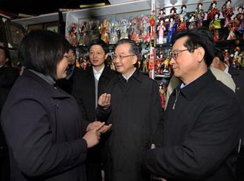 Chinese Premier Wen Jiabao (C) talks with a vendor at Yiwu International Trade City in east China's Zhejiang Province Nov. 21, 2008. Wen Jiabao made an inspection tour of Shanghai Municipality and Zhejiang Province from Nov. 21 to Nov. 23, 2008.[Xinhua Photo] 