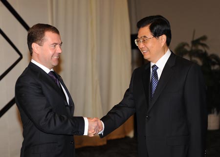 Chinese President Hu Jintao (R) shakes hands with Russian President Dmitry Medvedev during their meeting in Lima, capital of Peru, Nov. 23, 2008. 