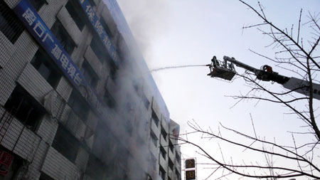 Firefighters extinguish a fire at a hotel in Lvliang City, East China's Shandong Province, November 22, 2008. Eight people were killed in the fire.