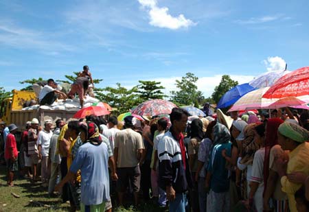 Refugees wait in lines for rice from United Nations World Food Programme at a settlement in Maguindanao, a southern province in Philippines, on Nov. 21, 2008. Violence between the government and Moro Islamic Liberation Front (MILF) has escalated in the southern Philippines over the past 4 months forcing over 60,000 families to displace, according to the official statistics. 