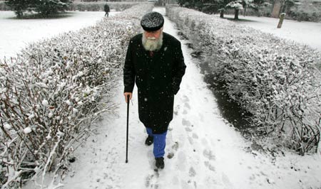 An old man walks along a snow-covered footpath in a park in Minsk, Belarus, November 22, 2008. Central and eastern parts of Europe have seen snowfalls in recent days. 