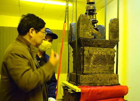 An archeologist talks with a worker about ways to remove and protect the miniature pagoda, which is believed to contain a part of Buddha's body in Nanjing, Jiangsu province November 22, 2008. 