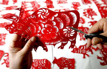 Pan Qiuai shows her paper-cutting work in her residence in Yanhu District of Yuncheng City, north China's Shanxi Province, November 20, 2008. [Photo: Xinhua] 
