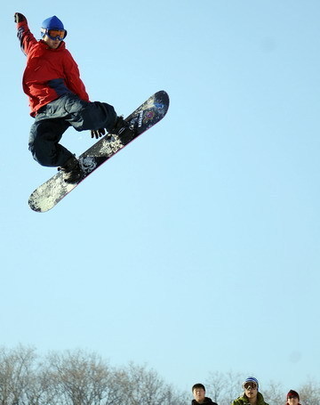 A man performs a jump during the opening ceremony of a snowboard park in Lotus Hill of Changchun, capital of northeast China's Jilin Province November 23, 2008. [Xinhua]