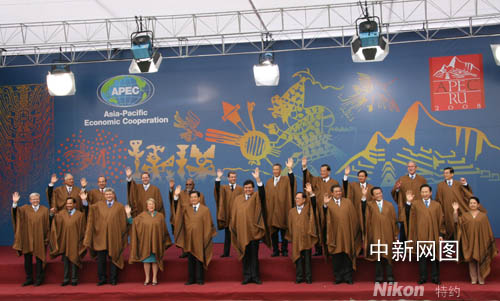 Leaders attending the APEC summit, dressed in local manteaus, pose for photos after the two-day meeting comes to end on Sunday, Nov 23, 2008.[China News Agency]