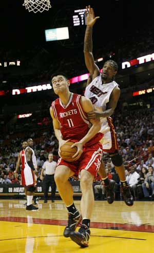 Houston Rockets Yao Ming (L) is fouled by Miami Heat's Udonis Haslem as he goes up for a basket during second quarter NBA basketball action in Miami, Florida Nov. 24, 2008. [Xinhua/Reuters]