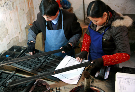 Villagers print the book of the Chen's family tree with wooden movable type in Wentang village of Qimen county, east China's Anhui Province, Nov. 23, 2008. This rare plate of movable type was inherited from ancestors of Wentang village for family tree printing, with only one plate and about 36200 wooden type left.