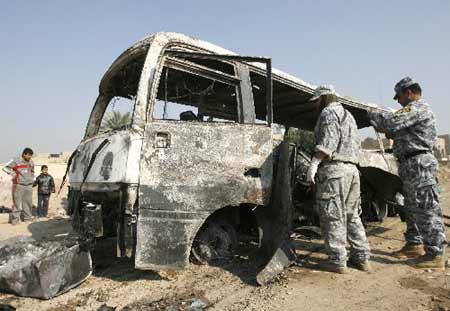 Policemen inspect a burnt bus at the site of a bomb attack in eastern Baghdad November 24, 2008.