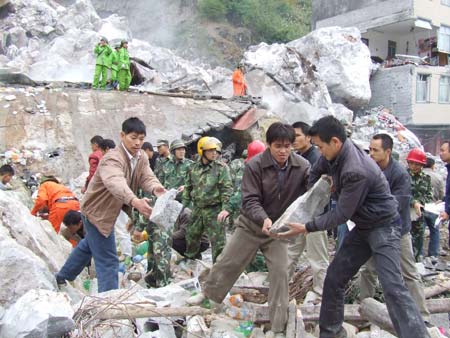 Rescuers remove stones to search for the missing at the spot of a landslide in south China's Guangxi Zhuang Autonomous Region, November 23, 2008.