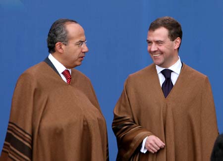 Mexican President Felipe Calderon (L) talks with Russian President Dmitry Medvedev as they pose for group photos of the 16th Economic Leaders' Meeting of the Asia-Pacific Economic Cooperation (APEC), in Lima, capital of Peru, Nov. 23, 2008. 