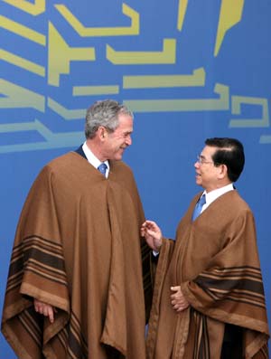 U.S. President George W. Bush (L) talks with Vietnamese President Nguyen Minh Triet as they pose for group photos of the 16th Economic Leaders' Meeting of the Asia-Pacific Economic Cooperation (APEC), in Lima, capital of Peru, Nov. 23, 2008. 