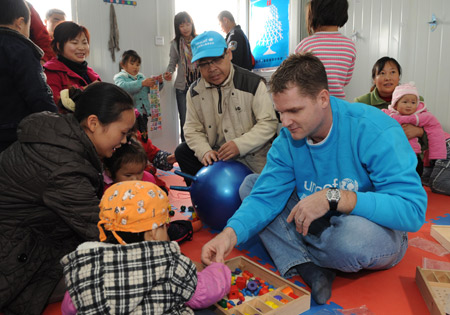 Scott Whoolery (R), an expert from the United Nations Children's Fund (UNICEF), plays with kids at a child friendship home, part of the children's protection program to quake-hit Sichuan, in Jiangyou, southwest China's Sichuan Province Nov. 23, 2008. The program, cooperated by the UNICEF and the All-China Women's Federation (ACWF), is expected to open 40 friendship home for psycho-socially reconstructing kids who suffered from the May 12 earthquake.