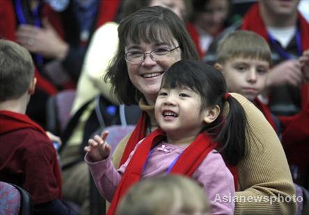 Liann Aiyu Downs and her adopted American mother Grace Told Downs are all smiles at a welcome ceremony in Beijing Sunday for a weeklong home reunion trip for 50 adopted China-born children. Most of the children, aged between six and ten, now live in the USA. 