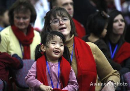 Liann Aiyu Downs and her adopted American mother Grace Told Downs are all smiles at a welcome ceremony in Beijing Sunday for a weeklong home reunion trip for 50 adopted China-born children. Most of the children, aged between six and ten, now live in the USA. 