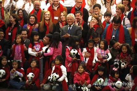 Li Xueju(C), Minister of Civil Affairs, takes a photo with families which take part in a weeklong home reunion trip. 