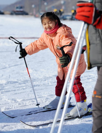 A girl smiles while practising skiing at a park in Lotus Hill of Changchun, capital of northeast China's Jilin Province November 23, 2008. 