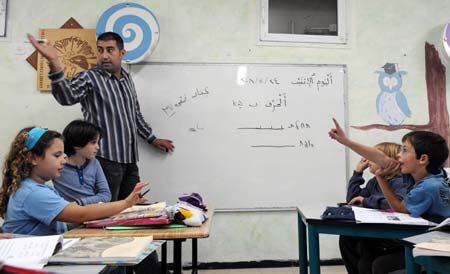  An Arab teacher gives an Arabic class to Jewish students at a Jewish-Arab school in Kafar Qara of Wadi Ara Region, north Israel, Nov. 24, 2008. Some 120 Arab students and 80 Jewish students from kindergarten to grade six study at the school, which was founded in 2003. Students of the school are co-taught by Jewish and Arab teachers in both Hebrew and Arabic. (Xinhua/Yin Bogu) 