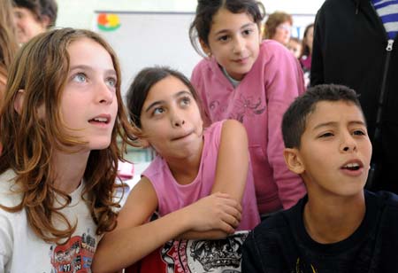 A Jewish student (L) plays with Arab students at a Jewish-Arab school in Kafar Qara of Wadi Ara Region, north Israel, Nov. 24, 2008. Some 120 Arab students and 80 Jewish students from kindergarten to grade six study at the school, which was founded in 2003. Students of the school are co-taught by Jewish and Arab teachers in both Hebrew and Arabic. 