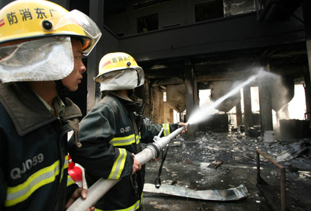 Firemen hose down the fire at a workshop in Xinbang Forestry Chemical Industry Co. Ltd. in Luoding City, south China's Guangdong Province, Nov. 25, 2008. A fire started at about 9:30 a.m. at the workshop, leaving two workers died and three others injured. [Xinhua]