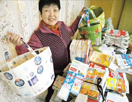 Jiang Meigui, 55, is obsessed with transforming all kinds of Tetra Pak milk boxes and soft drink bottles into fashionable handbags. [Shanghai Daily] 