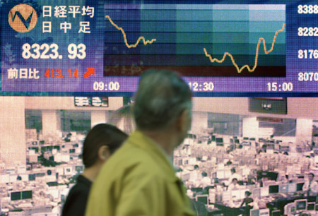 A man walks past an electronic stock price board in Tokyo, Japan, Nov. 25, 2008. Tokyo stocks closed sharply higher Tuesday amid gains logged in major markets in Asia. 