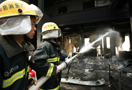 Firemen hose down the fire at a workshop in Xinbang Forestry Chemical Industry Co. Ltd. in Luoding City, south China's Guangdong Province, Nov. 25, 2008. A fire started at about 9:30 a.m. at the workshop, leaving two workers died and three others injured.