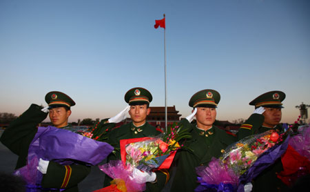 Ex-servicemen who completed their military service pose for a group photo at the Tiananmen Square, Beijing, November 25, 2008. 