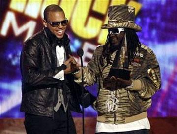 Singer Chris Brown (L) receives his award for pop/rock favorite male artist from T-Pain at the 2008 American Music Awards in Los Angeles November 23, 2008. [Reuters]