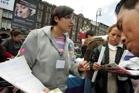 A volunteer presents publicity materials to visitors during a activity to mark the International day for the Elimination of Violence Against Women in Mexico City, capital of Mexico, on Nov. 25, 2008. 