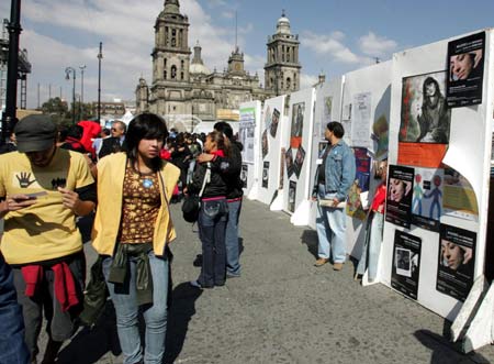 Mexican visitors visit a photo exhibition during an activity to mark the International day for the Elimination of Violence Against Women in Mexico City, capital of Mexico, on Nov. 25, 2008. 