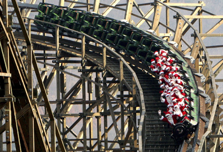 Employees of Everland amusement park ride a roller coaster wearing Santa Claus costumes at a Santa Academy class during a photo call at the amusement park, which is a part of the Samsung Group, in Yongin, South Korea on November 26, 2008. 