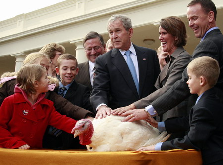 US President George W. Bush (C) gathers with children and National Turkey Federation officials as he pardons 'Pumpkin', the 2008 Thanksgiving turkey, during a ceremony in the Rose Garden of the White House in Washington November 26, 2008. 