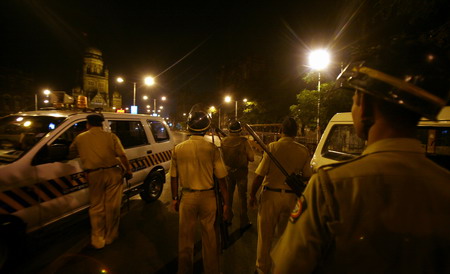 Police stand guard after shootings took place inside a railway station in Mumbai November 26, 2008.