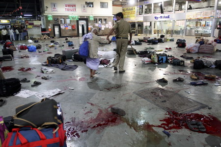 A policeman walks with an elderly man after shootings by unidentified assailants at a railway station in Mumbai November 26, 2008. At least 101 people have been killed in a series of attacks in Mumbai, police said. 