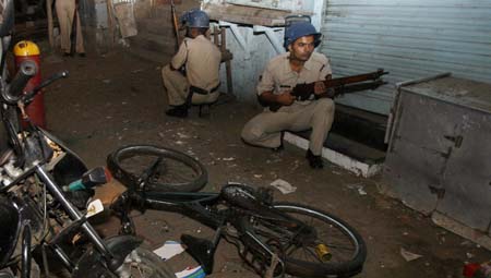 Police take up position at a blast site in Mumbai November 27, 2008. Gunmen killed at least 101 people in a series of attacks in India's financial capital Mumbai and troops began moving into one of two five-star hotels on Thursday where Western hostages were being held, local television said.
