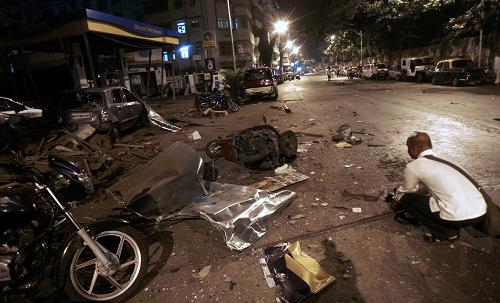 A man crouched down among the site of a bomb blast in Mumbai November 26, 2008. At least 101 people were killed in a series of attacks apparently aimed at tourists in India's financial capital Mumbai on Wednesday night, with television channels saying Westerners were being held hostage at two five-star hotels. At least 250 people have been wounded, police said. 