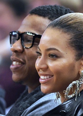Jay-Z and his wife Beyonce Knowles watch the New York Knicks play the Cleveland Cavaliers in the third quarter of their NBA basketball game at Madison Square Garden in New York, November 25, 2008. [Agencies]