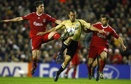 Liverpool's Xabi Alonso (L) and Javier Mascherano (R) challenge Olympique Marseille's Vitorino Hilton for the ball during their Champions League soccer match in Liverpool, northern England, Nov. 26, 2008. 