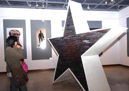 A visitor views a sculpture during an exhibition of Zhejiang's famous sculptors at the gallery of China Academy of Art in Hangzhou, capital of east China's Zhejiang Province, Nov. 26, 2008. 