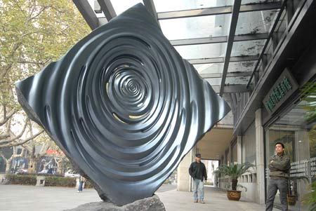 A visitor views a sculpture during an exhibition of Zhejiang's famous sculptors at the gallery of China Academy of Art in Hangzhou, capital of east China's Zhejiang Province, Nov. 26, 2008. 