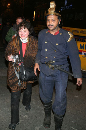 A foreign guest staying at the Taj Hotel reacts after being rescued by a fireman in Mumbai November 27, 2008. At least 101 people have been killed in attacks by gunmen in Mumbai, police said on Thursday.